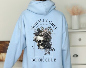 Könnte beinhalten: Hellblauer Hoodie mit einem Totenkopf- und Blumenmotiv und dem Text "Morally Grey Book Club" auf der Rückseite.