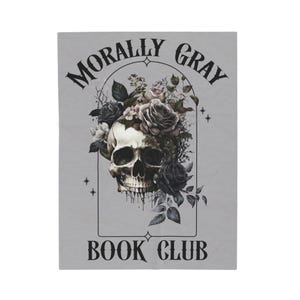 May include: A light gray blanket featuring a skull with a floral arrangement of roses and leaves. The text "MORALLY GRAY BOOK CLUB" is arched above and below the skull design in black.