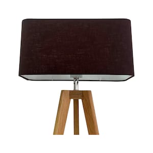 May include: A contemporary table lamp featuring a dark brown rectangular lampshade. The lampshade is supported by a tripod base crafted from light-coloured wood. The lamp's design is minimalist, fitting for diverse interior aesthetics.