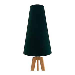May include: A contemporary table lamp featuring a dark green, cone-shaped lampshade. The shade is supported by a light-coloured, three-legged wooden base. The lamp's design is minimalist, suitable for modern interiors.