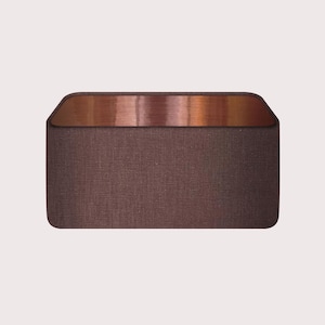May include: A rectangular brown fabric ottoman with a copper top.