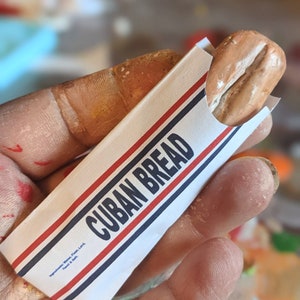 Miniature replica of Cuban Bread in it's authentic bag (available as a pin, magnet or ornament)