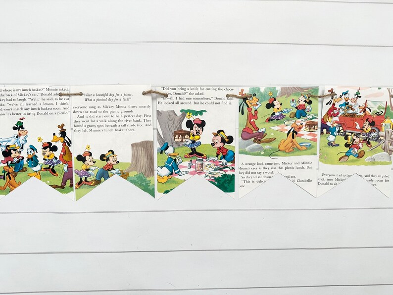 May include: A vintage paper banner featuring Mickey Mouse and his friends enjoying a picnic. The banner is decorated with colorful illustrations and text from a children's book. The text reads, "What a beautiful day for a picnic, what a picnic day for a little..."