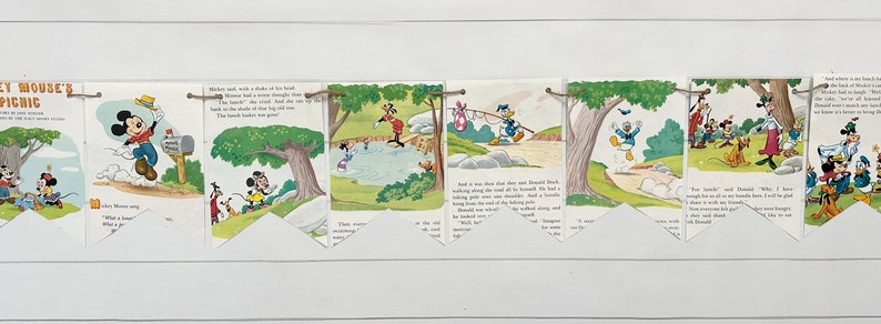 May include: A vintage Mickey Mouse's Picnic banner with illustrations of Mickey Mouse and his friends. The banner is made of paper and has a string attached to each end. The banner is decorated with illustrations of Mickey Mouse and his friends, including Donald Duck, Goofy, and Pluto. The banner is perfect for a Mickey Mouse themed party.