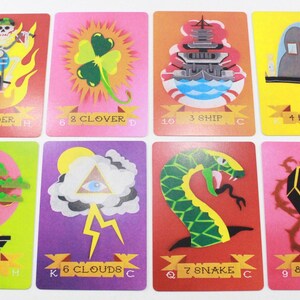 Puede incluir: Un juego de nueve cartas de juego con ilustraciones coloridas. Las cartas representan un jinete, un tr&eacute;bol, un barco, una casa, un &aacute;rbol, nubes, una serpiente, un ata&uacute;d y una calavera. Las cartas est&aacute;n numeradas del 1 al 9 y tienen s&iacute;mbolos de palo.