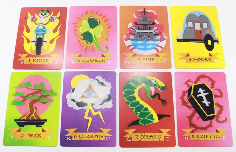 Puede incluir: Un juego de nueve cartas de juego con ilustraciones coloridas. Las cartas representan un jinete, un tr&eacute;bol, un barco, una casa, un &aacute;rbol, nubes, una serpiente, un ata&uacute;d y una calavera. Las cartas est&aacute;n numeradas del 1 al 9 y tienen s&iacute;mbolos de palo.