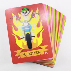 Puede incluir: Una carta de juego roja con un esqueleto montando una motocicleta a trav&eacute;s de las llamas. La carta tiene el n&uacute;mero 9 y el texto "1 Rider".