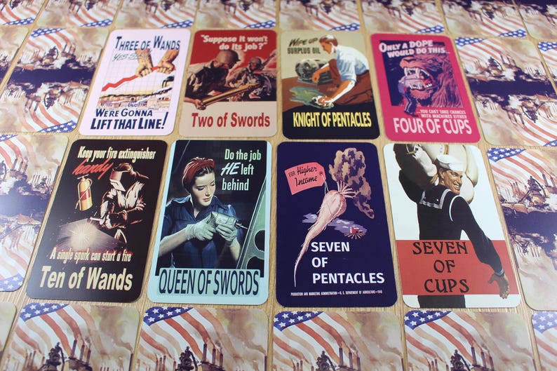 Puede incluir: Un conjunto de cartas de tarot de estilo vintage con temas patri&oacute;ticos. Cada carta presenta ilustraciones y texto &uacute;nicos, como "Three of Wands", "Two of Swords" y "Four of Cups". Las cartas est&aacute;n dispuestas sobre una superficie con un dise&ntilde;o de bandera estadounidense.