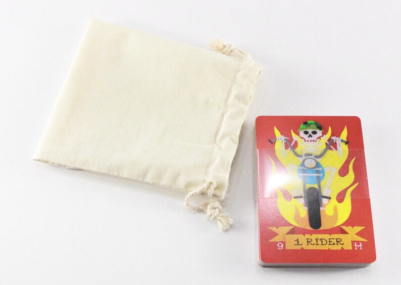 Puede incluir: Una carta de juego roja con un esqueleto montando una motocicleta a trav&eacute;s de las llamas. La carta est&aacute; numerada con el n&uacute;mero 9 y tiene el texto "1 Rider". La carta forma parte de una baraja de cartas y viene con una bolsa de cord&oacute;n blanco.
