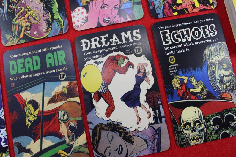 May include: A collection of vintage-style comic book art cards. Each card features a unique illustration with bold colors and text, including phrases like "DEAD AIR" and "DREAMS." The cards have a retro aesthetic, reminiscent of classic comic book covers.