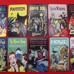 May include: A collection of ten vintage-style, rectangular metal signs with horror-themed comic book art. Each sign features a unique title and illustration in vibrant colors, evoking a retro aesthetic. Titles include "Flames," "Footsteps," and "The Haunting."