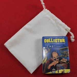 Pode incluir: Uma revista "COLLECTOR" azul e amarela com o texto "Deixe ir o que n&atilde;o lhe serve mais. Voc&ecirc; n&atilde;o precisa de mais coisas, precisa de menos medo" ao lado de um saco branco com cord&atilde;o numa superf&iacute;cie vermelha.