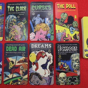 May include: A collection of vintage-style cards with horror-themed illustrations and text. The cards feature images of monsters, skulls, and other eerie elements. A deck of cards with skull and crossbones design is also present.