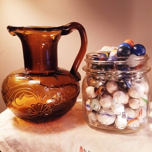 Unique Vintage Dark Amber handblown raised floral design small glass pitcher.open/rough pontil,bubbles,applied handle. Fantastic condition