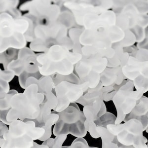 May include: A large quantity of small, white, plastic flower-shaped beads.