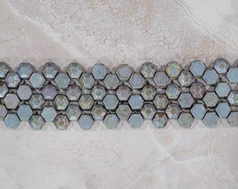 May include: A row of hexagonal ceramic tiles in shades of blue and gray with a subtle iridescent sheen.