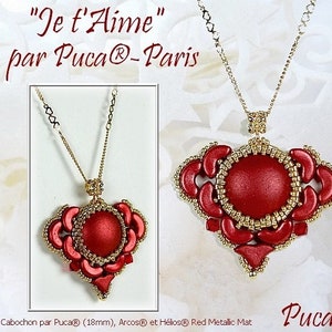 May include: A gold chain necklace with a red and gold heart-shaped pendant. The pendant features a red cabochon surrounded by gold beads. The text "Je t'Aime" and "par Puca®-Paris" is visible in the image.