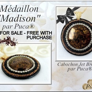 Könnte beinhalten: Ein schwarzer und brauner Perlenanhänger mit einem Jet-Bronze-Cabochon. Der Anhänger ist mit "Médaillon "Madison" par Puca®" und "Cabochon Jet Bronze par Puca®" beschriftet.