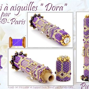 May include: A purple and gold needle case with a wooden base and a beaded top. The case is decorated with beads and rhinestones. The text "Étui à aiguilles "Dora" par Puca®-Paris" is visible on the image.