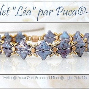 May include: A beaded bracelet with a geometric design. The bracelet features blue-grey, diamond-shaped beads and small gold-colored beads. The text "Bracelet "Léa" par Puca®-Paris" is at the top.