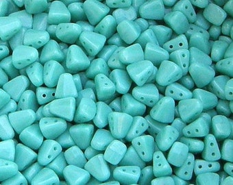 May include: A large quantity of turquoise blue glass beads in a triangular shape with three holes in each bead.
