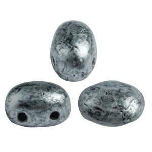 Puede incluir: Tres cuentas ovaladas grises con un acabado metálico y un patrón de mármol. Las cuentas tienen dos agujeros cada una.