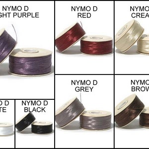 May include: Assortment of Nymo D thread spools in various colors, including light purple, red, cream, white, black, grey, and brown.