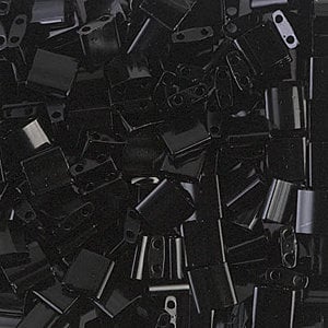 May include: A large pile of black square-shaped beads with two holes in each bead.