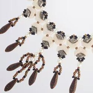 May include: A white and brown beaded necklace with a layered design. The necklace features round, white beads with a silver-like finish and brown teardrop-shaped beads. The necklace has a cascading effect with multiple strands of beads.