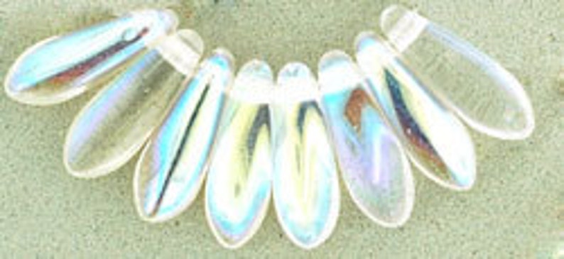 May include: A strand of iridescent glass beads in a teardrop shape. The beads are clear with a rainbow sheen.