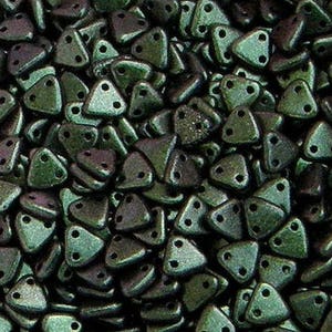 May include: A close-up of a pile of dark green triangle-shaped beads with two holes in each bead.