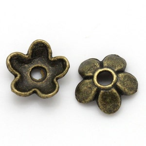 May include: Two antique gold-toned metal flower-shaped bead caps with a hole in the center.