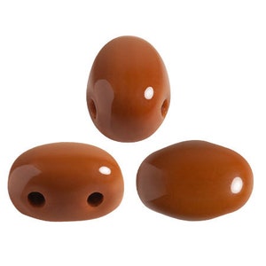 Può includere: Tre perline in ceramica marrone con due fori ciascuna. Le perline sono di forma ovale e hanno una finitura lucida.