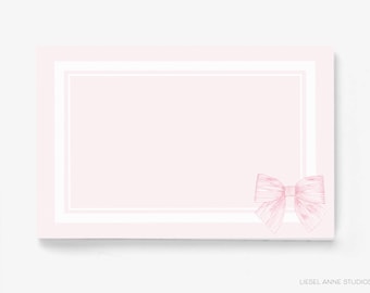 May include: A blank pink card with a white border and a pink bow in the bottom right corner.
