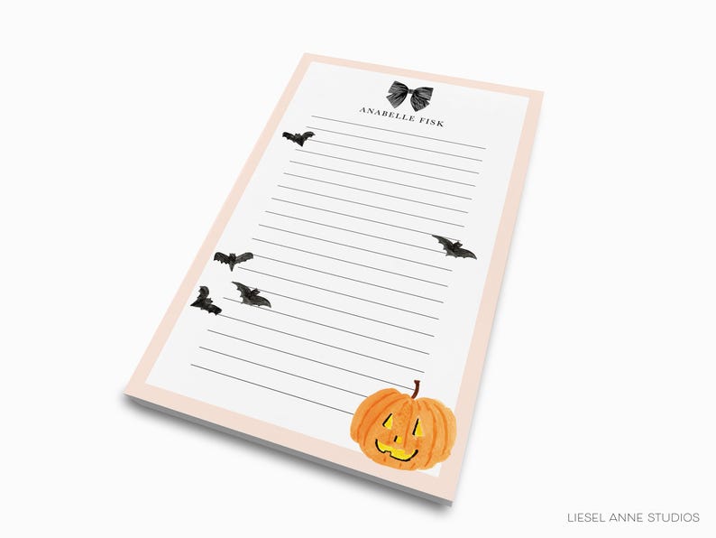 a lined paper pad with a pumpkin and bats design, and the text "ANABEL TIK" at the top.