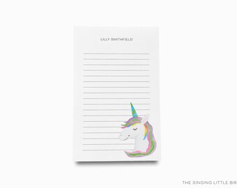 May include: A white notepad with lined paper and a unicorn illustration. The notepad has the name "Lilly Smithfield" printed at the top.