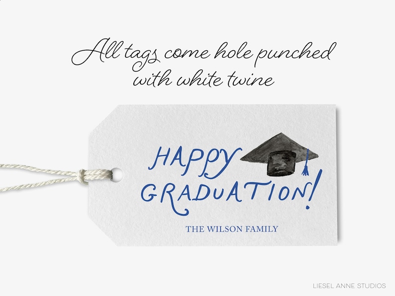 The image is a graduation tag with a graduation cap and mortarboard, accompanied by the text "All tags come hole punched with white twine" and "HAPPY GRADUATION!" The tag also includes the text "THE WILSON FAMILY" and "LIESEL ANNE STUDIOS".