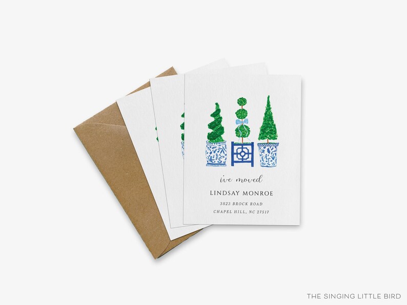 a set of greeting cards with a design of three topiary trees in blue and white pots, along with text indicating that the cards are for "ive moved" and are addressed to "Linda Monroe".