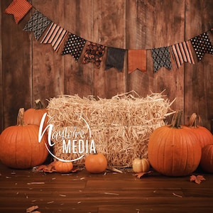 May include: A rustic wooden background with a hay bale in the center. A string of orange, black, and white Halloween flags hangs above the bale. There are several orange pumpkins in front of the bale, with a few smaller pumpkins scattered around.