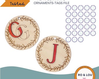 Op de afbeelding: Een set van 26 ronde houten ornamenten met een ontwerp van een krans van bladeren en een rode letter in het midden. De ornamenten zijn lasergesneden en klaar om te worden gepersonaliseerd. De letters zijn A tot en met Z en een nummerteken. De afbeelding bevat ook de tekst "Laser Tested" en "Commercial or Personal Use SVG | PDF | EPS | DXF".