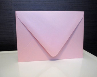 May include: A light pink envelope with a pointed flap.