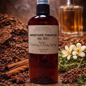 May include: A brown glass bottle of "Heritage Tobacco" room, clothing, and body spray, 4.5 fl oz, with a black spray nozzle. The label reads "M & T SCENTS Handcrafted for you since 2013". The background includes spices and a second bottle.