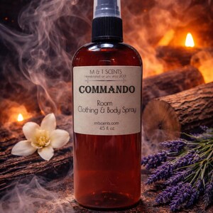 May include: A brown bottle of "COMMANDO" room, clothing, and body spray. The label includes the brand "M&T SCENTS" and the website mtscents.com. The bottle is 4.5 fl oz. The background includes a flower, lavender, and smoke.