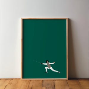 May include: A framed art print showing a minimalist illustration of a fencer. The fencer is in white and grey against a deep green background. The frame is made of light-coloured wood, adding a natural touch to the artwork. The artwork is displayed on a wooden surface.