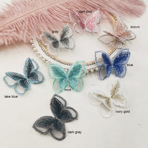 May include: Assortment of embroidered butterfly appliques in various colors, including dark pink, gray, brown, blue, lake blue, mint, ivory gold, and dark gray.