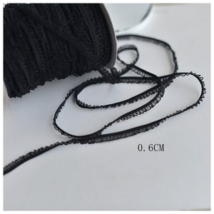 May include: Black elastic trim with a ruffled edge. The trim is 0.6 inches wide.