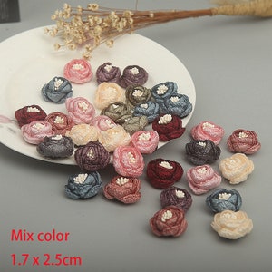 Könnte beinhalten: Sortiment von 25 kleinen Stoffblumen in verschiedenen Farben, darunter Rosa, Rot, Blau, Grün und Beige. Jede Blume misst etwa 1,7 cm x 2,5 cm.