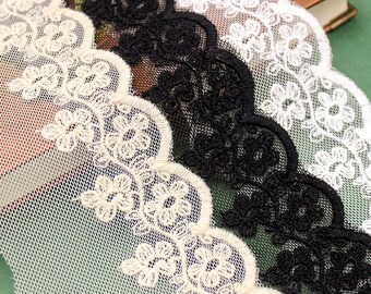 Peut inclure: Trois galons de dentelle de différentes couleurs avec un bord festonné et un motif floral. La dentelle est blanche, noire et crème.