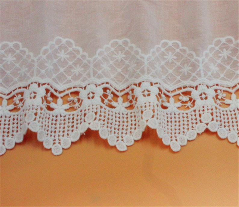 May include: White cotton lace trim with a scalloped edge and a delicate floral pattern.