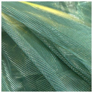 Puede incluir: Tela de malla metálica verde y dorada con un tejido fino y uniforme. La tela tiene un brillo sutil y una textura suave y fluida.